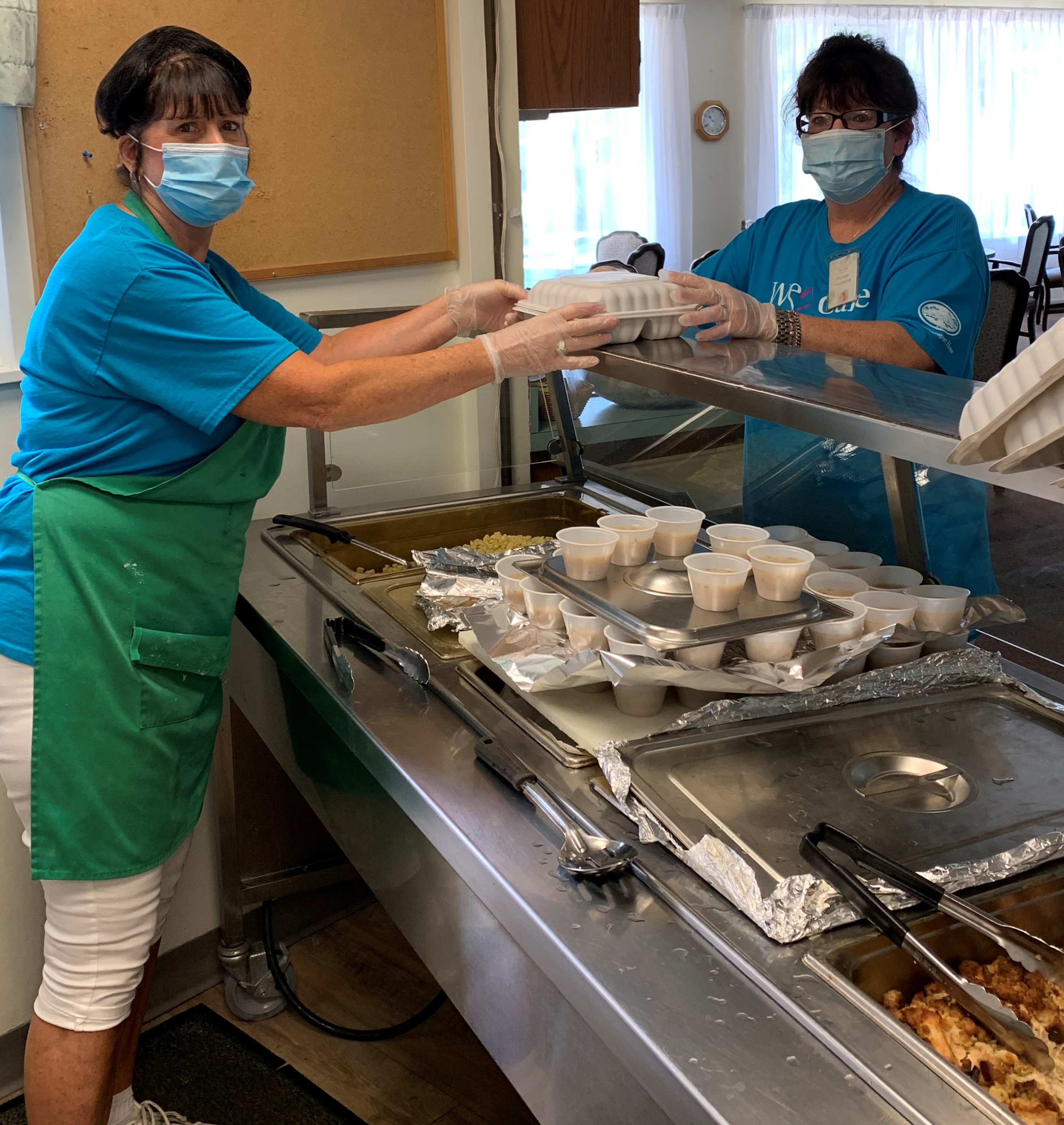 Deb Cranmer packing lunch and handing to Tammy Mitchell for delivery6